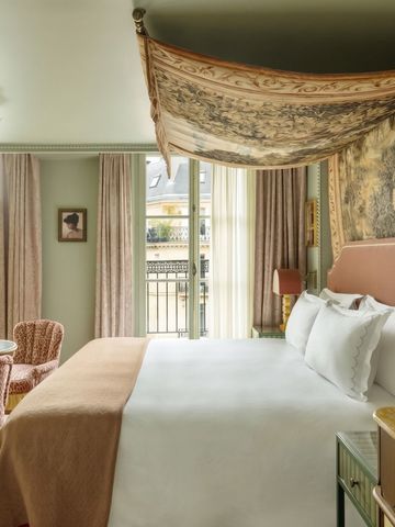 Elegantes Hotelzimmer mit Baldachin und Fenster zur Stadt