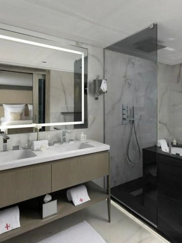 Zeitgemäßes Badezimmer mit Regenwalddusche und Marmorverkleidung