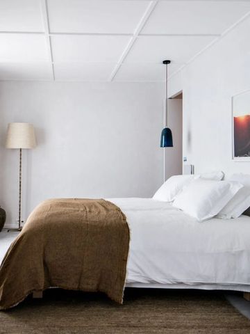 Ruhiges Schlafzimmer mit Doppelbett, minimalistischer Dekoration und großer Fensterfront