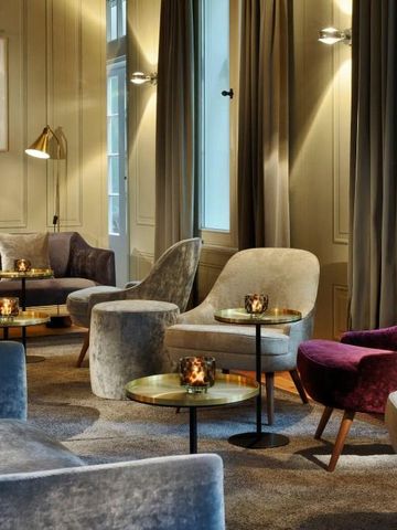 Gemütliche Hotellounge mit eleganten Sesseln und Kerzenlicht an Tischen.