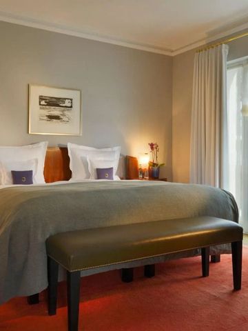 Luxuriöses Hotelzimmer mit Doppelbett und großen Fenstern für natürliche Beleuchtung