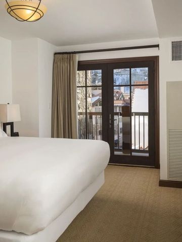 Helles Hotelzimmer mit einem großen Bett und Zugang zu einem Balkon mit Aussicht