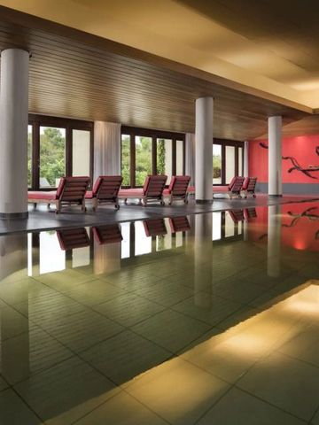 Eleganter Innenpool mit Liegestühlen und natürlichem Licht.