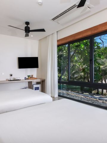 Zimmer mit großem Fenster und Blick auf üppige Vegetation