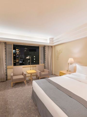 Geräumiges Hotelzimmer mit Doppelbett und großer Fensterfront im The Okura Tokyo