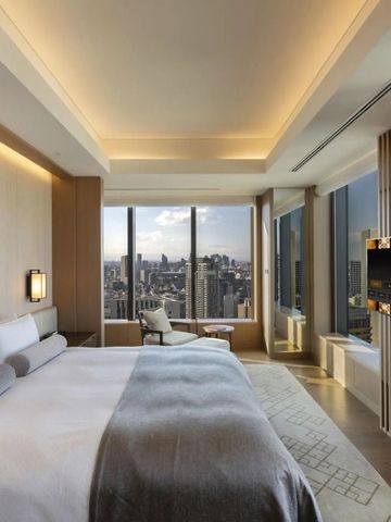 Helles Schlafzimmer mit großem Fenster und Stadtansicht