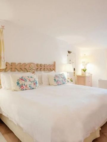 Helles Hotelzimmer mit großem Bett und floralen Akzenten.