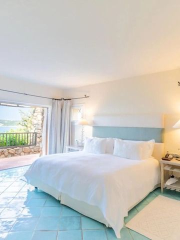 Geräumiges Hotelzimmer mit Blick auf das Meer von einem Balkon.