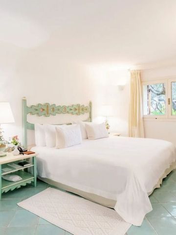 Helles Schlafzimmer in Pastelltönen mit grüner Bettumrandung