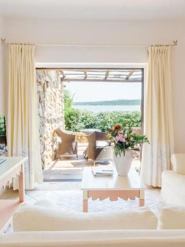 Helles Wohnzimmer einer Suite mit Blick auf das Meer und Terrasse