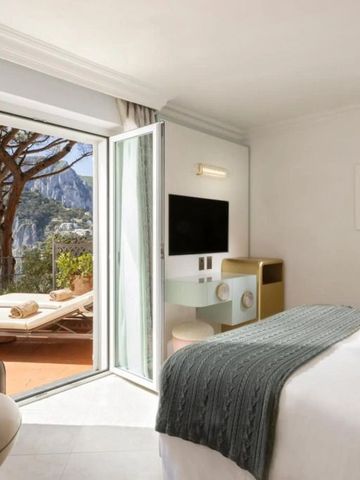 Helles Hotelzimmer mit Zugang zu einer Terrasse und Meerblick