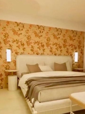 Geräumiges Schlafzimmer mit gemusterter Tapete und Doppelbett im Hotel Punta Tragara