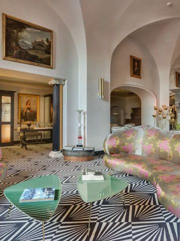 Opulenter Lounge-Bereich mit kunstvollen Sofas und historischen Gemälden