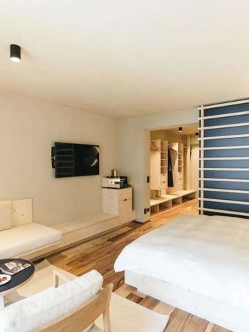 Helles Hotelzimmer mit Doppelbett, modernen Möbeln und dezenter Dekoration
