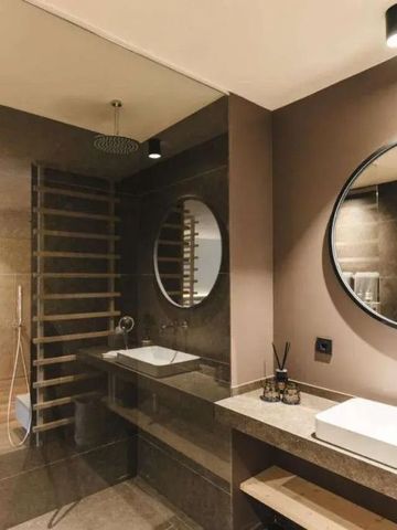 Stilvolles Badezimmer mit Doppelwaschbecken und runden Spiegeln