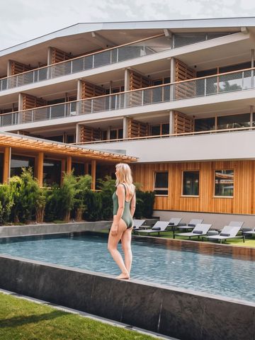 Frau am Infinity-Pool mit Blick auf Hotel