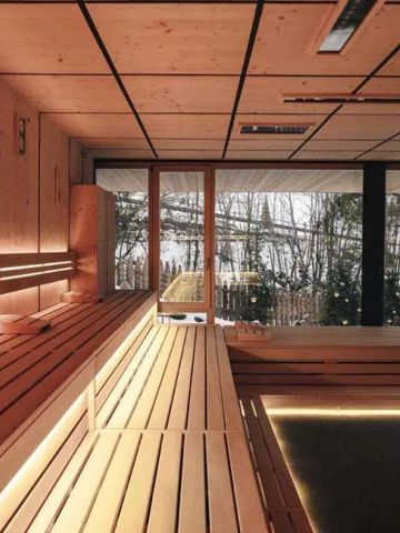 Helle Sauna mit Holzverkleidung und Blick auf verschneite Landschaft
