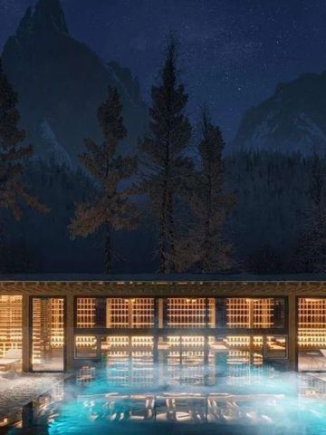 Beleuchteter Außenbereich mit Pool und Berglandschaft bei Nacht