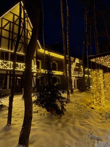 Beleuchtetes Hotelgebäude im Winter mit Lichterketten und schneebedecktem Boden.