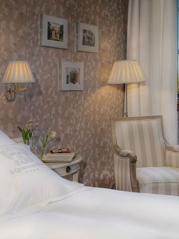 Luxuriöses Gästezimmer mit gestreiftem Sessel und Tageslicht