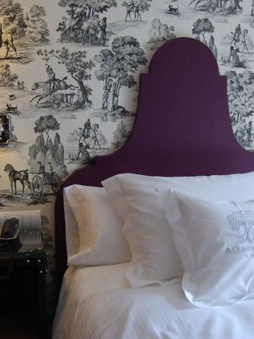 Zimmer mit lila Kopfteil und Wanddekoration im klassischen Design