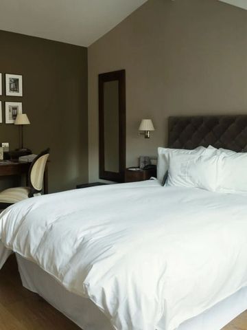 Modernes Doppelzimmer mit elegantem Schreibtisch und Kunstwerken