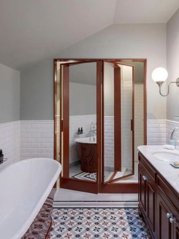 Helles Badezimmer mit freistehender Badewanne und eleganter Spiegelwand