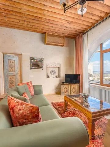 Elegantes Wohnzimmer mit Holzbalkendecke und großer Fensterfront