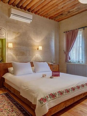 Schlafzimmer mit Holzbalkendecke und romantischem Doppelbett