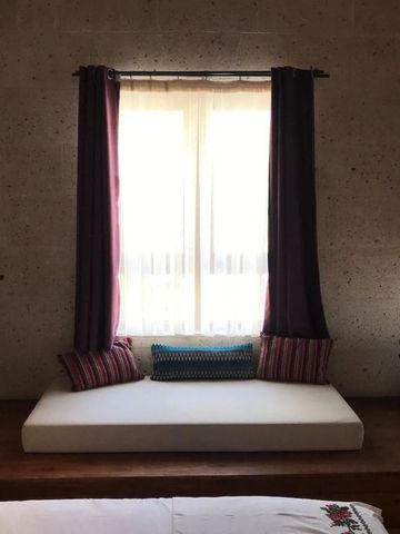 Gemütliche Sitzecke mit Kissen und natürlichem Licht.