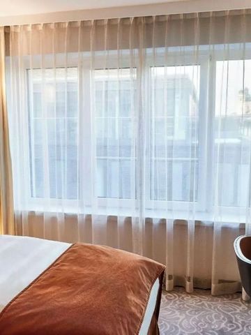 Helles Hotelzimmer mit großem Fenster und modernem Design