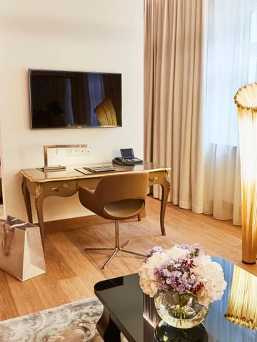 Hotelzimmer mit Schreibtischbereich, Fernseher und stilvoller Beleuchtung