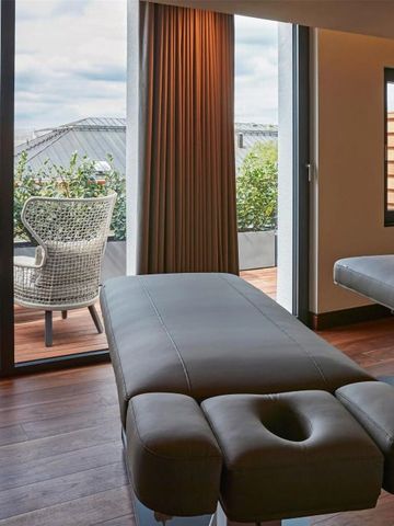 Wellnessraum mit Massageliege und Blick auf Terrasse