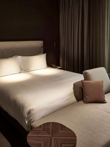 Einladendes Hotelzimmer mit Doppelbett und dezenter Beleuchtung