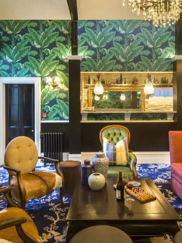 Luxuriöser Loungebereich mit exotischer Tapete und stilvollen Möbeln