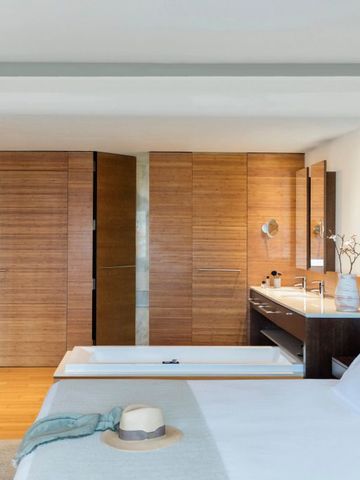 Geräumiges Hotelzimmer mit modernen Holzakzenten und offener Badewanne