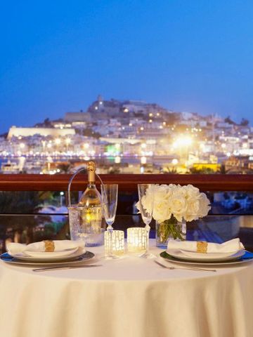 Romantisch gedeckter Tisch auf einer Terrasse mit Blick auf die Stadtlichter