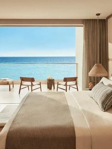 Zimmer mit Blick auf das Meer durch eine offene Fensterfront
