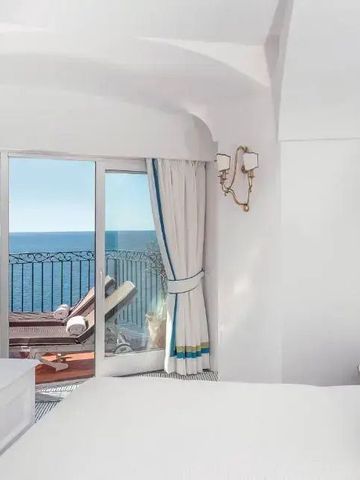 Lichtdurchflutetes Zimmer mit Blick auf eine Terrasse und das Meer