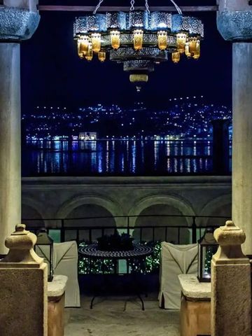 Imaret Hotel bei Nacht mit leuchtendem Kronleuchter und Meerblick.