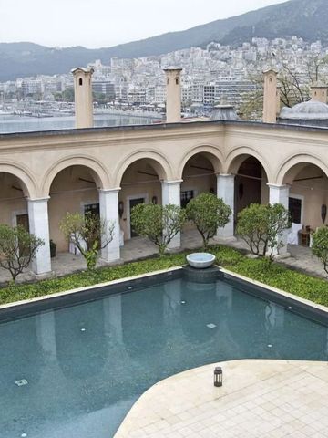 Hof mit Pool und Arkaden vor Stadt- und Bergkulisse
