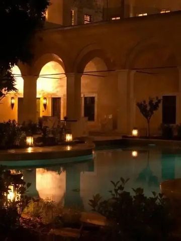 Beleuchteter Innenhof mit Pool bei Nacht