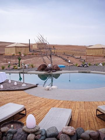 Luxuriöser Poolbereich mit Liegestühlen und Blick auf die Wüste