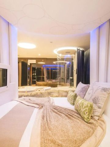 Luxuriöses Zimmer mit moderner Beleuchtung und Blick ins Badezimmer.