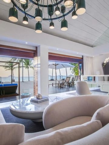 Elegantes Wohnzimmer mit Blick auf den Strand durch große Fenster