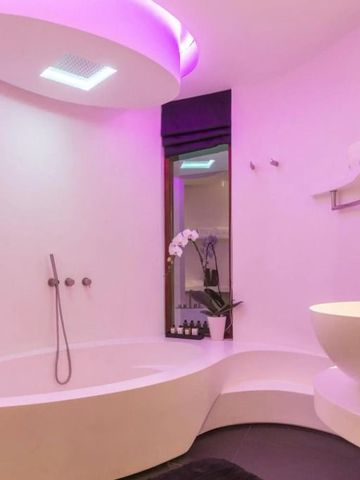 Modernes Badezimmer mit eleganter Badewanne und violetter Beleuchtung