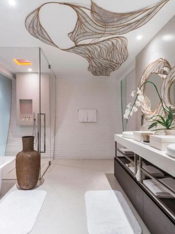Geräumiges Badezimmer mit Doppelwaschbecken und kunstvollen Spiegeln