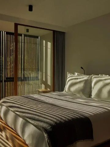 Elegant beleuchtetes Schlafzimmer mit Bett und Holzdetails