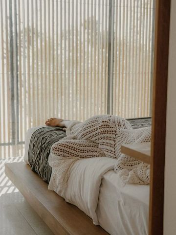 Gemütliches Bett mit dekorativer Decke im modernen Raum
