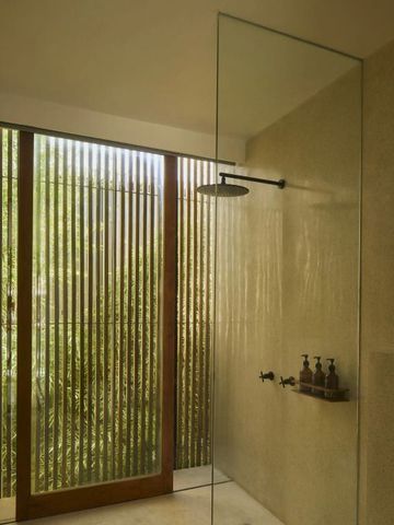 Elegantes Badezimmer mit Regendusche und Holzjalousien